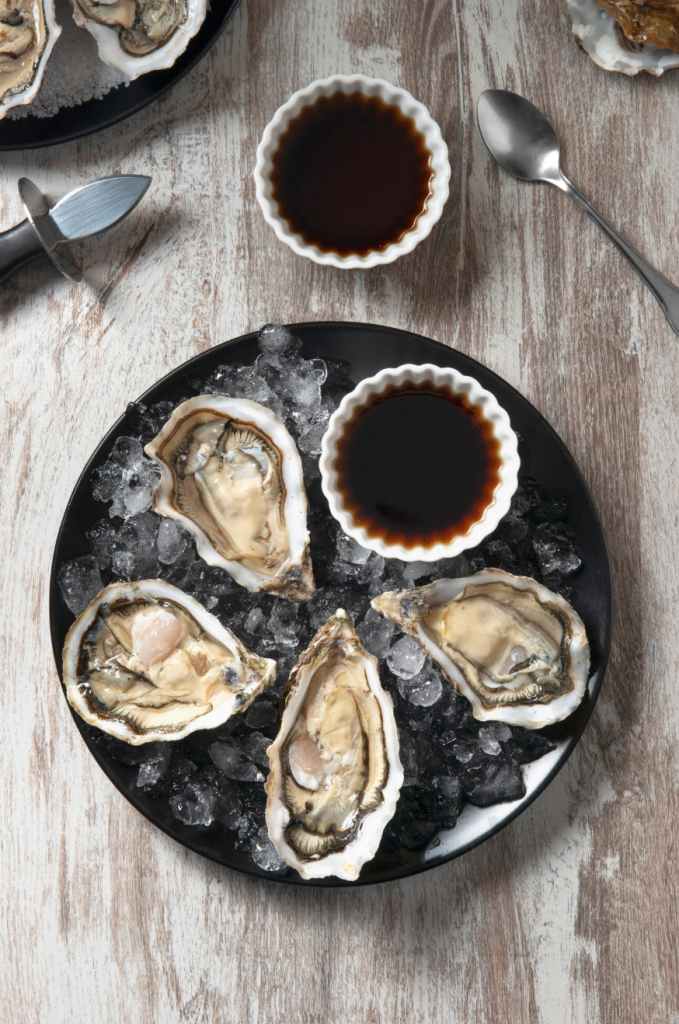 oysters on a plate with ice and sauce