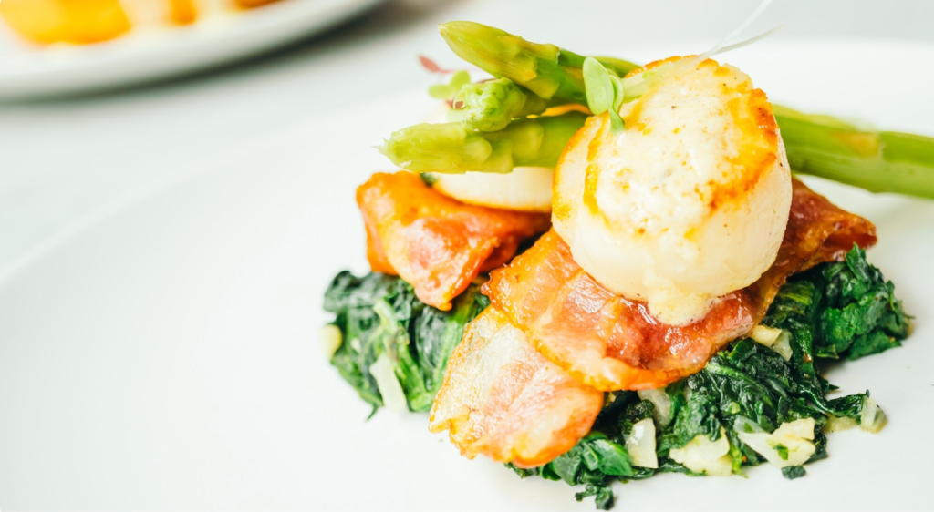 a gourmet meal of scallop, asparagus and spinach