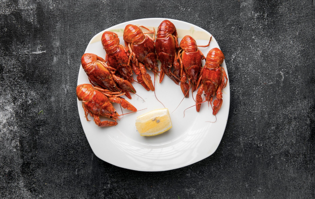seven cooked lobsters with a slice of lemon