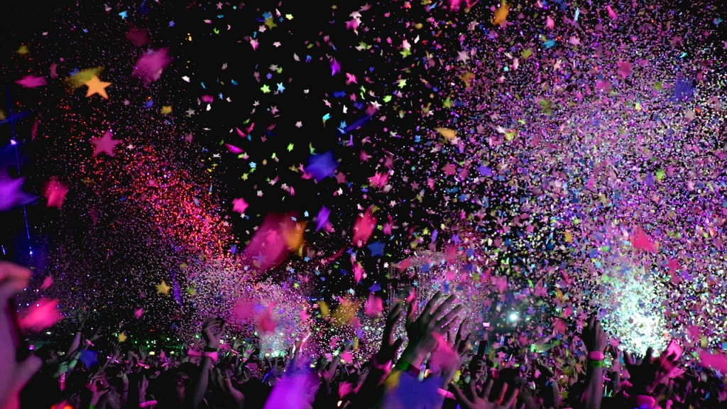 Hands throwing confetti in the air at a club in Bali