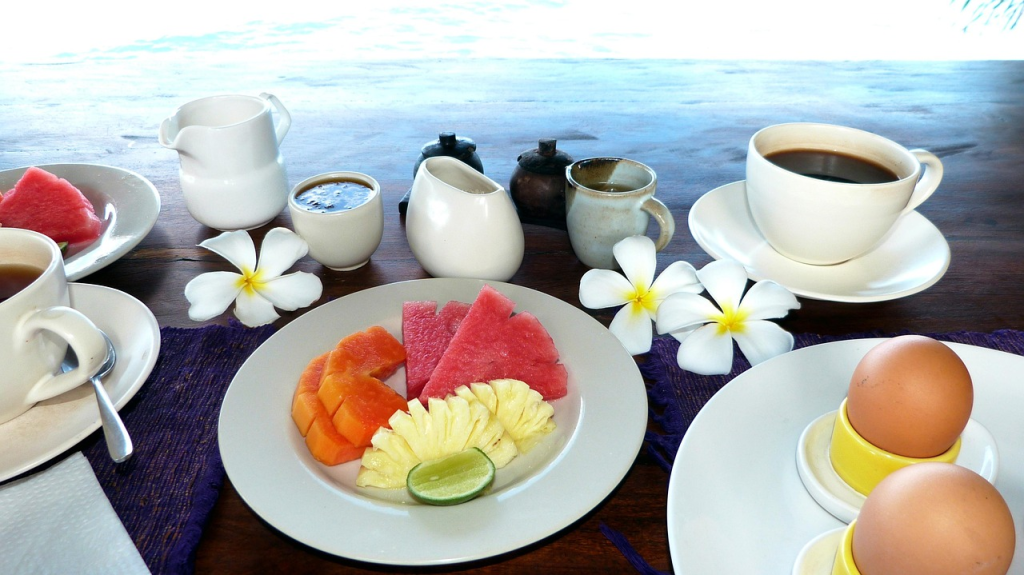 A breakfast spread of coffee, boiled eggs and fresh fruit