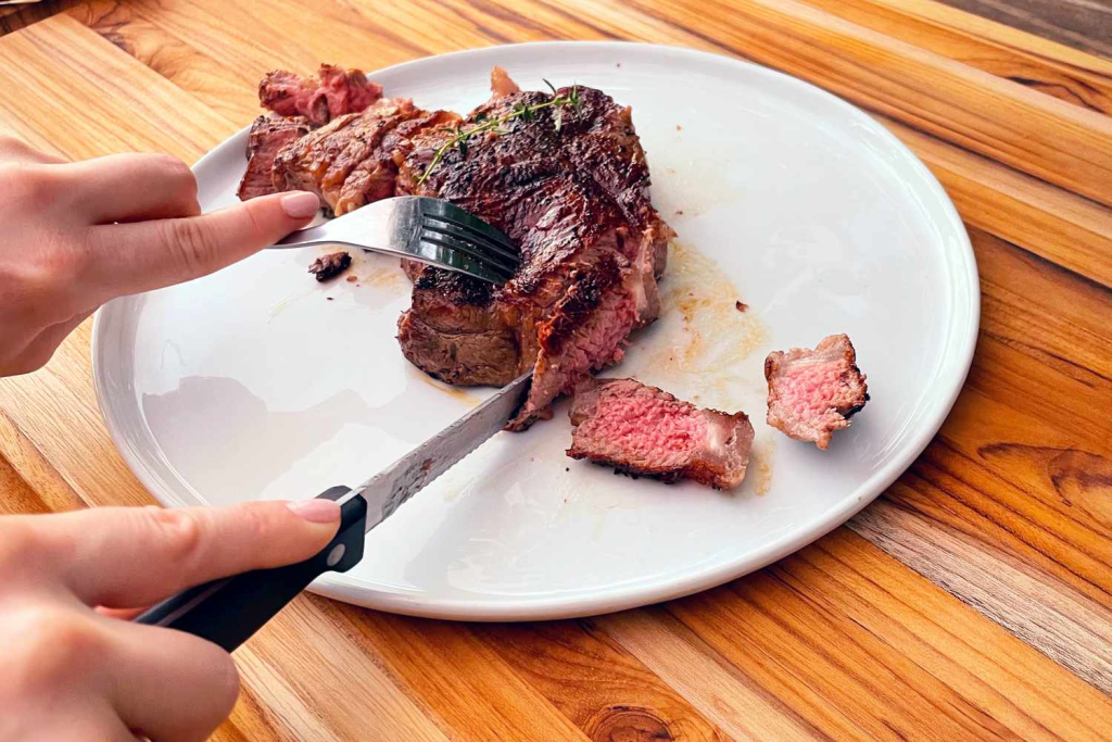 A steak being eaten with a fork and knife