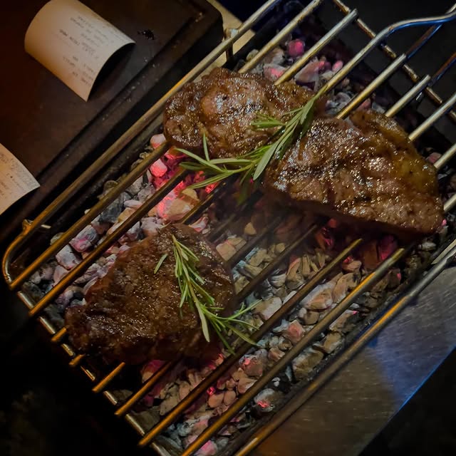 Two steaks on a grill with rosemary garnish from Batubara in Ubud, Bali