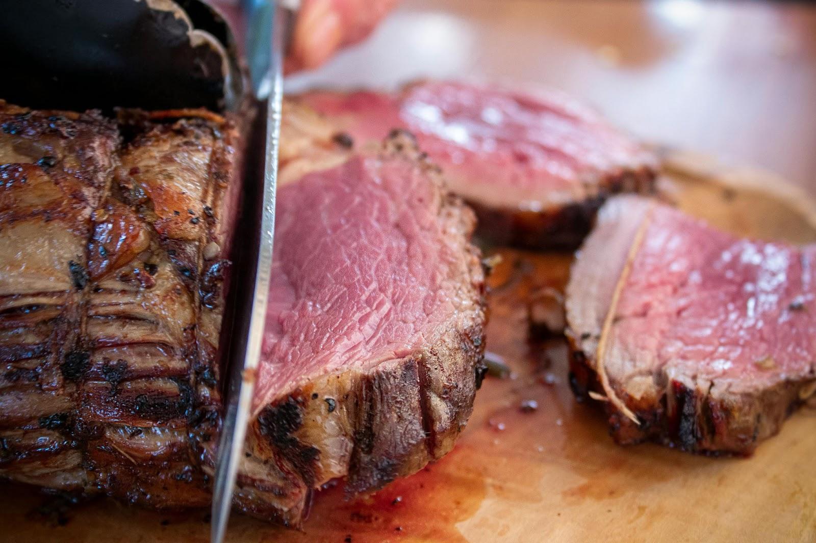A knife cutting into beef