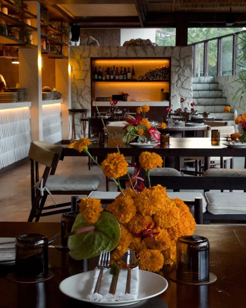 Tropical flower arrangements on dining tables at NARI - Fire-Influenced Bistro, Bali
