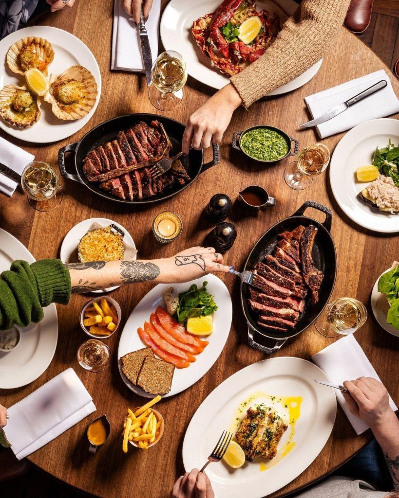 A spread of steak and dishes from a steakhouse